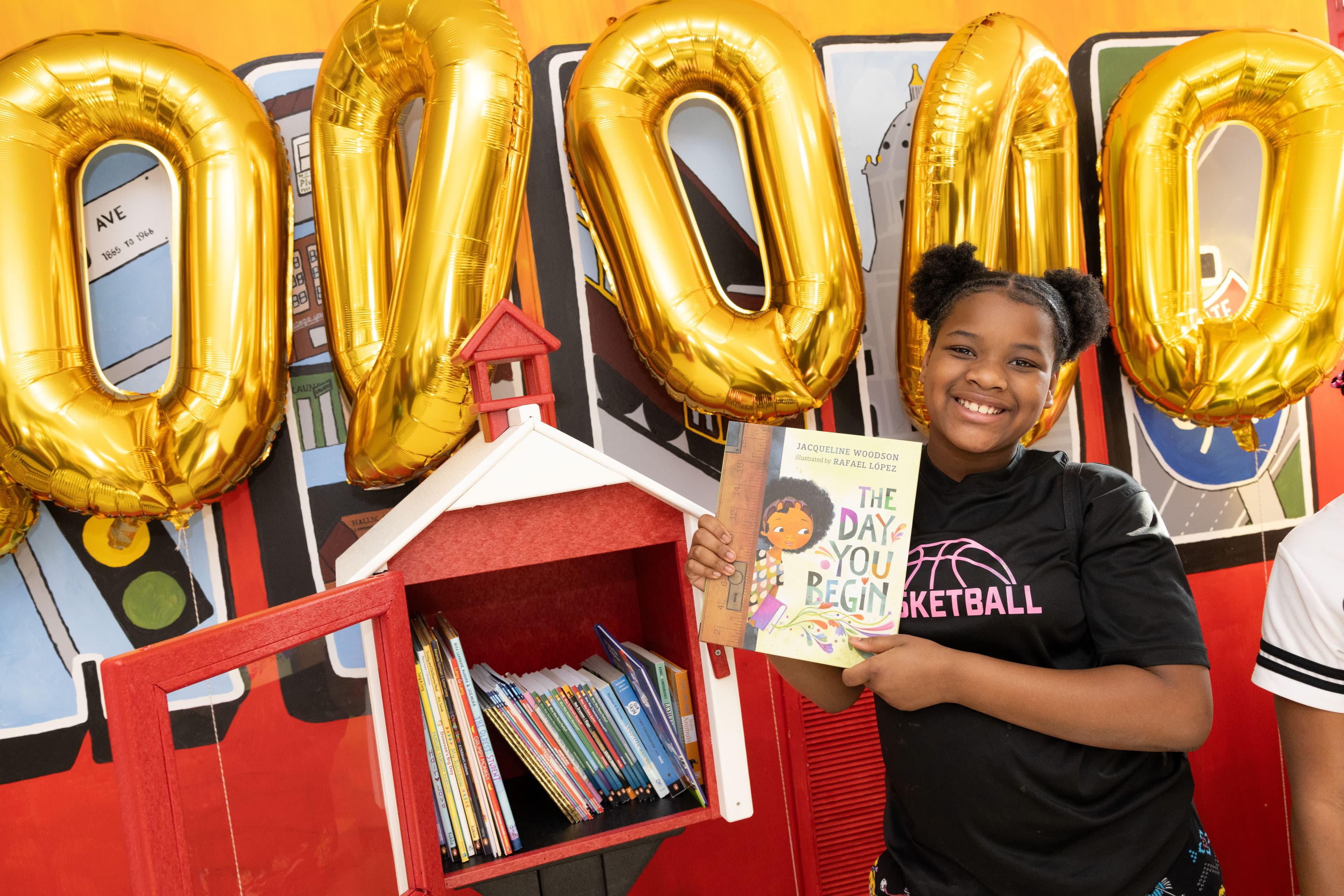 Little Free Library book-sharing box in garden full of flowers